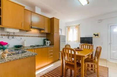 a kitchen with wooden cabinets and a table with chairs at ★Traditional House★Heart of Oldtown★ Amazing views in Albufeira