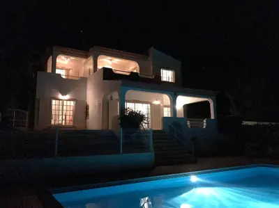 a house at night with a swimming pool in front of it at Vivenda ROSA Albufeira in Fontainhas
