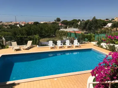 a swimming pool with chaise lounge chairs at Vivenda ROSA Albufeira in Fontainhas