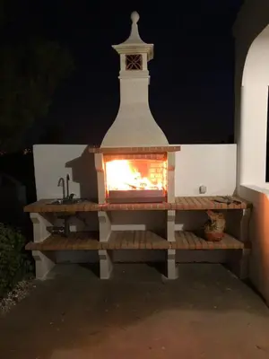a brick oven with a fire inside of it at Vivenda ROSA Albufeira in Fontainhas