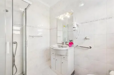 a white bathroom with a sink and a shower at Villa Chiquito Albufeira - Private Pool&Parking - BBQ&AC&WI-FI in Albufeira