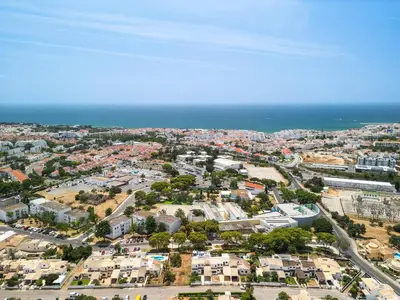an aerial view of a city with houses and the ocean at Villa Chiquito Albufeira - Private Pool&Parking - BBQ&AC&WI-FI in Albufeira