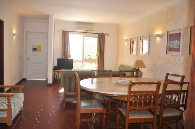 a pool with two chairs and a table and an umbrella at Stylish well-equipped, private pool, close to amenities, free AC Wifi in Quarteira