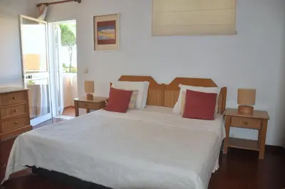 a small bedroom with two beds and a window at Stylish well-equipped, private pool, close to amenities, free AC Wifi in Quarteira