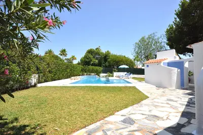 a living room with a couch and a tv at Delightful single-storey villa, private pool, free air conditioning and wifi in Vilamoura