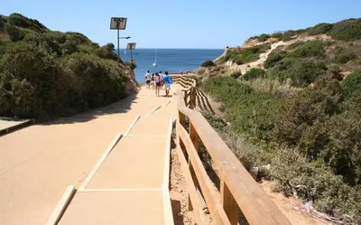 a group of people riding bikes on a path near the ocean at Pine Tree Seaside Apartments 500m to Beach in Albufeira