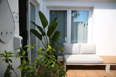 a living room with a white couch and a window at Pine Tree Seaside Apartments 500m to Beach in Albufeira
