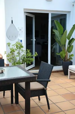 a patio with a table and chairs and plants at Pine Tree Seaside Apartments 500m to Beach in Albufeira