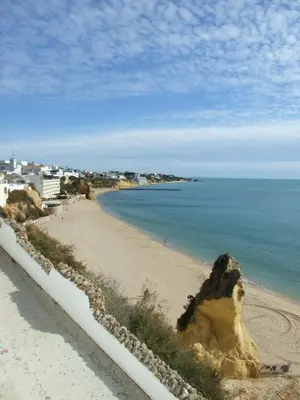 a sandy beach next to a body of water at Casa da Vila in Albufeira