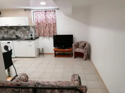 a living room with a couch and a tv and a kitchen at Oceana in Faro