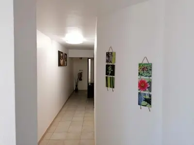 a hallway with white walls and art on the walls at Oceana in Faro