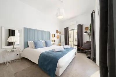 a bedroom with a large bed with a blue blanket at Downtown Lux Apartment in Faro