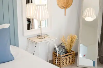 a bedroom with a table with a lamp and a mirror at Downtown Lux Apartment in Faro