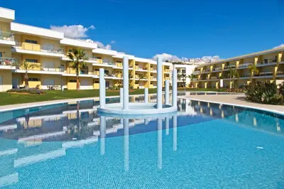 a swimming pool in front of a building at Albufeira Premium Apartment in Albufeira