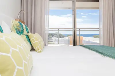 a bedroom with a bed with a large window at Alfagar Aparthotel in Albufeira