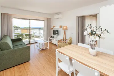 a living room with a dining room table and a couch at Alfagar Aparthotel in Albufeira