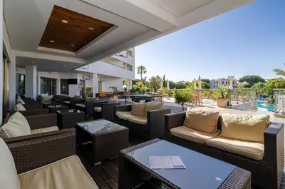 a patio with tables and chairs and a pool at Alfagar Aparthotel in Albufeira