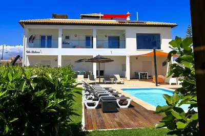a villa with a swimming pool in front of a house at Villa Bellevue in Albufeira