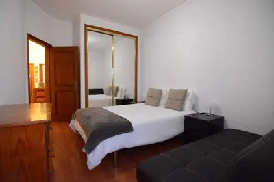 a bedroom with a large white bed and a couch at Wonderful view in the city center in Faro
