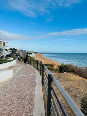 a brick sidewalk next to a beach with the ocean at Apartment Old Town Ferreira de Castro in Albufeira