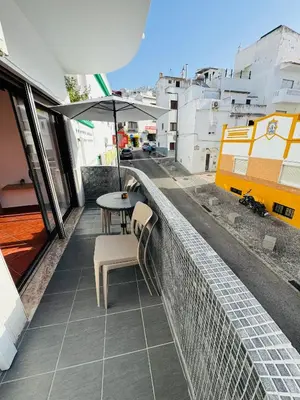 a balcony with a table and an umbrella at Apartment Old Town Ferreira de Castro in Albufeira