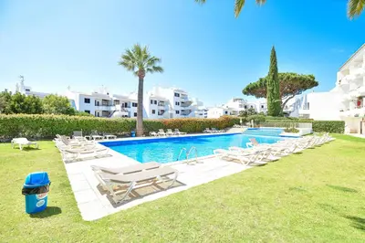a bedroom with a large white bed with blue pillows at Estúdio Solar B by MTPhomes in Albufeira
