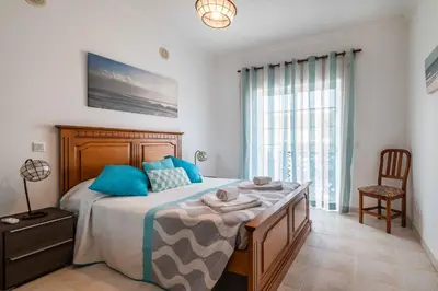 a bedroom with a large bed with blue pillows at Bosque São José by Algarneto in Albufeira