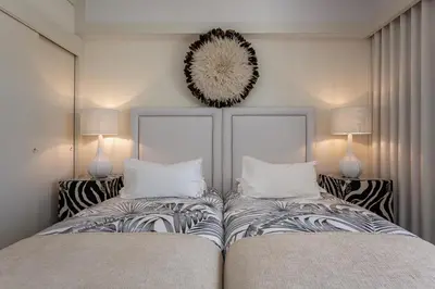 a bedroom with two beds and a mirror on the wall at Victory Beach House in Quinta do Lago