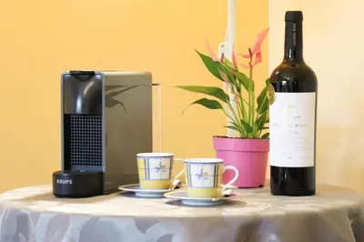 a bottle of wine and two cups on a table at VILLA EBER - independent 1 & 2 bedroom apartments, pool, air con, fast Wi-Fi, near old town of Albufeira and beaches in Albufeira