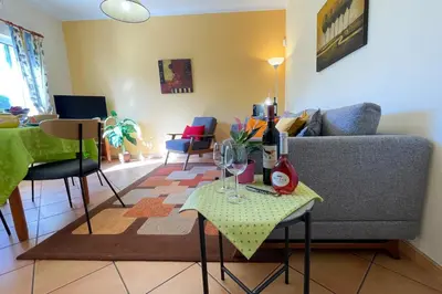 a living room with a couch and a table with wine glasses at VILLA EBER - independent 1 & 2 bedroom apartments, pool, air con, fast Wi-Fi, near old town of Albufeira and beaches in Albufeira