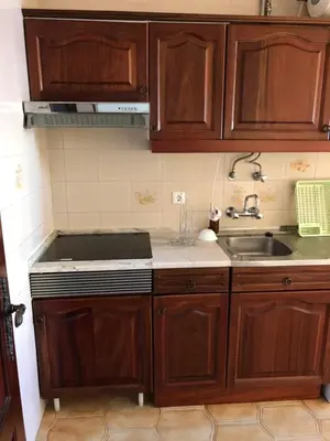 a kitchen with wooden cabinets and a sink at Apartment Sea View 20m to beach - TOP Quarteira ALGARVE in Quarteira