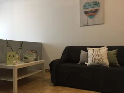 a living room with a black couch and a table at Apartment Sea View 20m to beach - TOP Quarteira ALGARVE in Quarteira