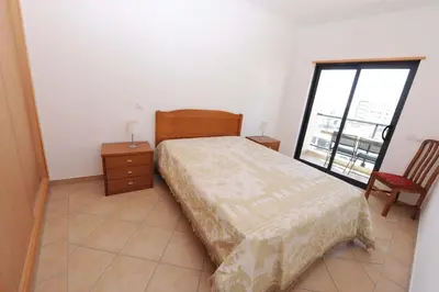 a bedroom with a bed and a window at Quarteira Beach in Quarteira