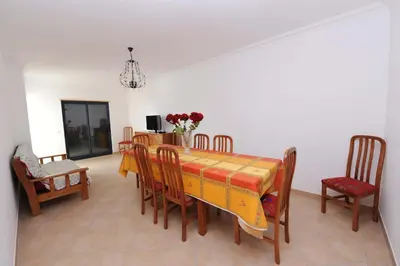 a dining room with a yellow table and chairs at Quarteira Beach in Quarteira
