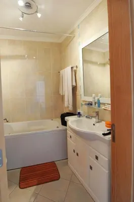 a bathroom with a tub and a sink and a mirror at Quarteira Beach in Quarteira