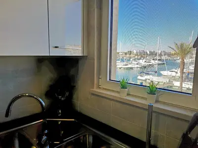 a kitchen sink with a window with a view of a harbor at Marina Plaza 162 - Clever Details in Vilamoura