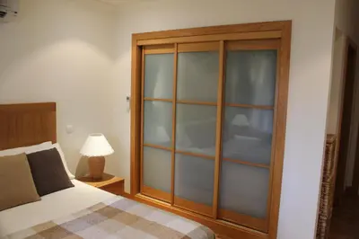 a bedroom with a bed and a glass cabinet at Luxury 3 Bedroom Apartment on Gated Complex in Quarteira