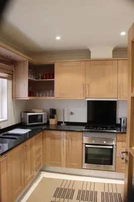 a kitchen with wooden cabinets and a stove top oven at Luxury 3 Bedroom Apartment on Gated Complex in Quarteira