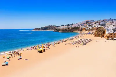 a group of people on a beach with the ocean at Natural Grey Albufeira in Albufeira
