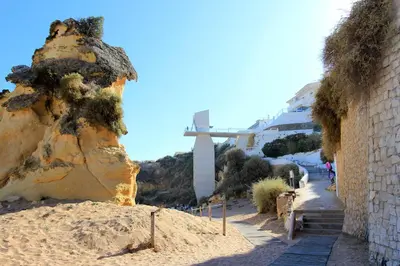 a cross on a hill next to a rock at Natural Grey Albufeira in Albufeira