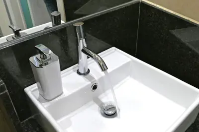 a white sink with a faucet in a bathroom at Guest House Sao Filipe in Faro