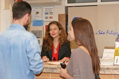 three people standing around a counter in a store at Guest House Sao Filipe in Faro