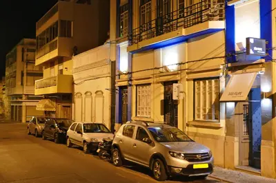 a row of cars parked on a city street at night at Guest House Sao Filipe in Faro