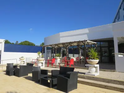 a hotel with a swimming pool in front of a building at Hotel ibis Faro Algarve in Faro