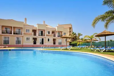 a large swimming pool in front of a building at Aquamar Albufeira Aparthotel in Albufeira