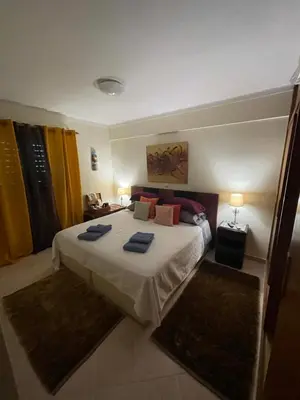 a bedroom with a large bed with blue towels on it at Casa #SerJo in São Brás de Alportel