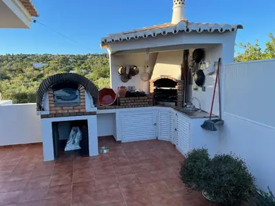 an outdoor kitchen with a pizza oven on a patio at Casa #SerJo in São Brás de Alportel