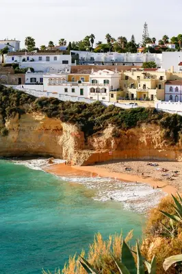 a beach with large rocks in the ocean at Charming Apartment in Quarteira - 50 sqm - Balcony with View in Quarteira