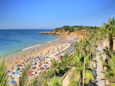 a beach with many people with umbrellas and the ocean at V3, Villa Jardins Branqueira6 near Beach, Albufeira in Albufeira