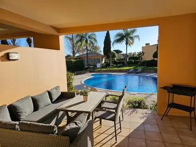 a patio with a couch and a table and a pool at Citadela I, Golfe, Pool and Falesia Beach in Vilamoura
